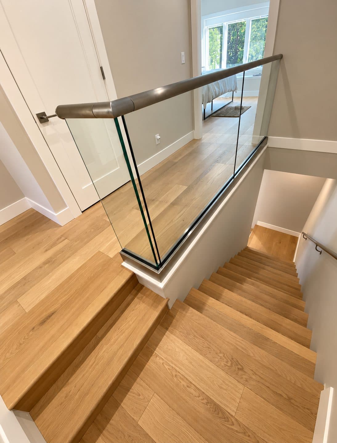 Wood staircase and landing behind a glass railing