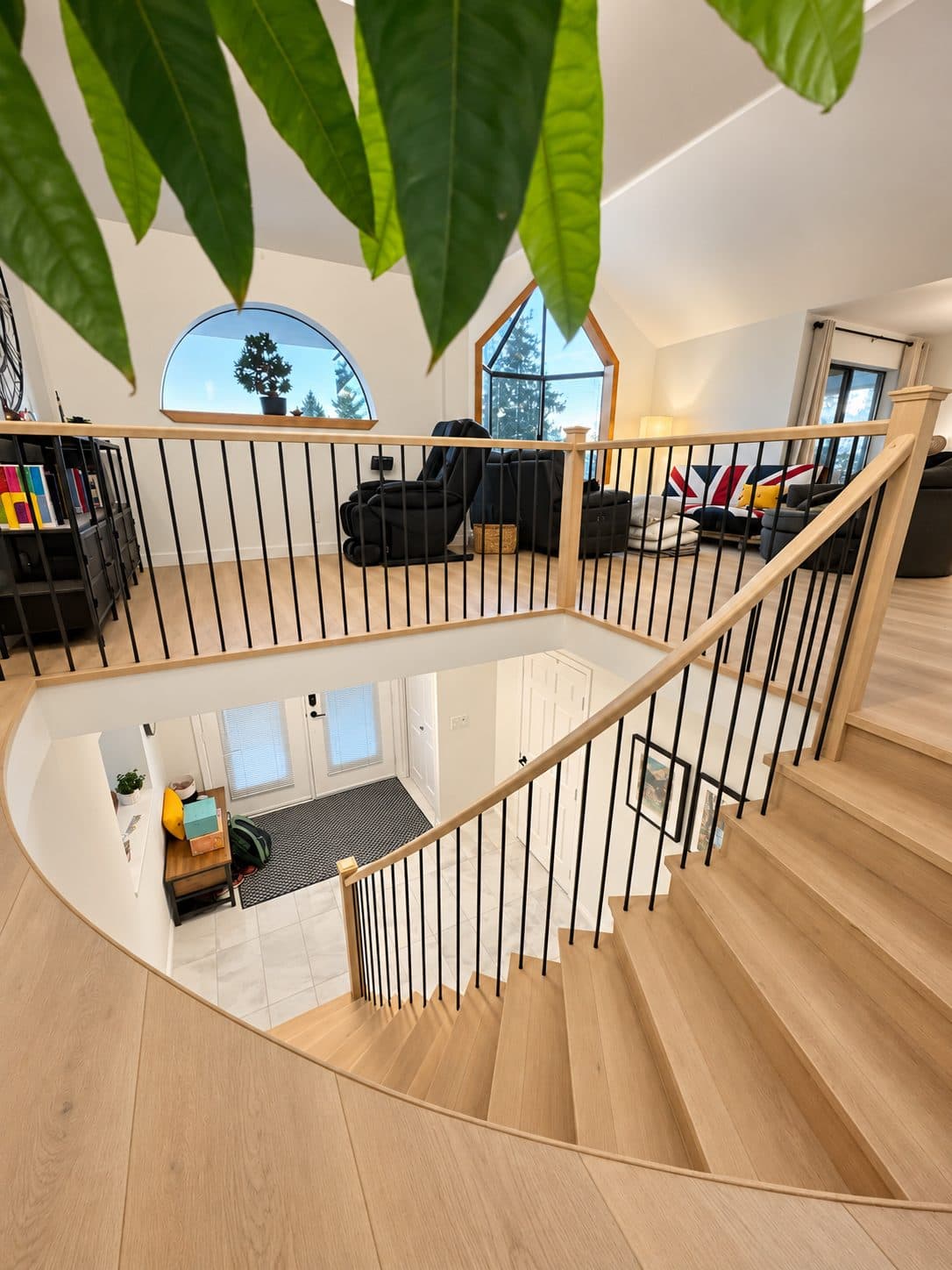 Curved staircase and landing with black balusters