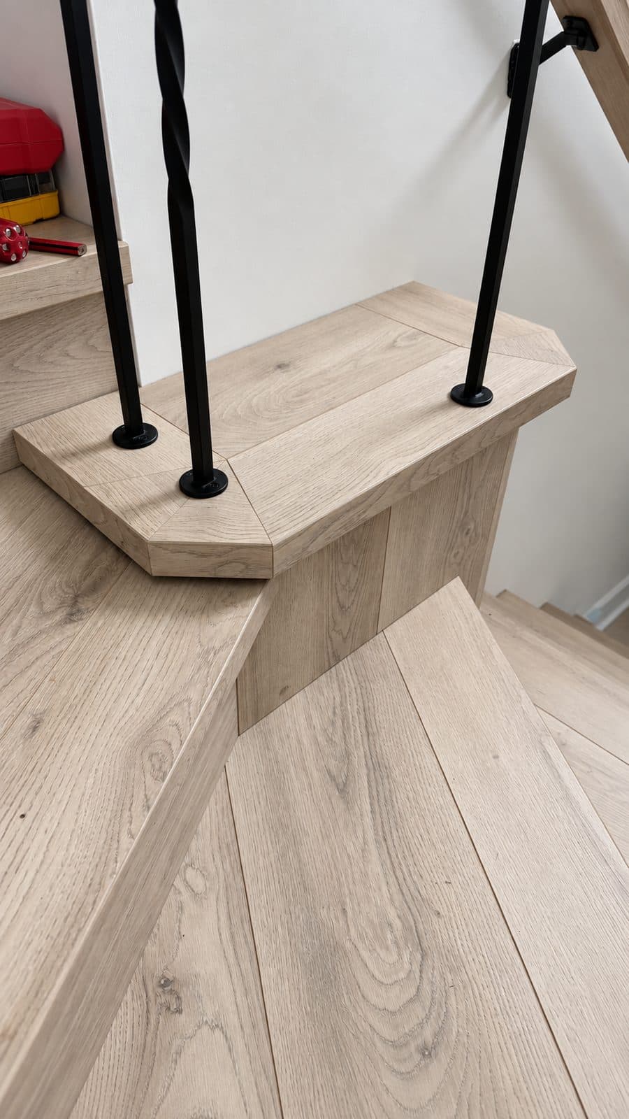 Angled wood step with black balusters
