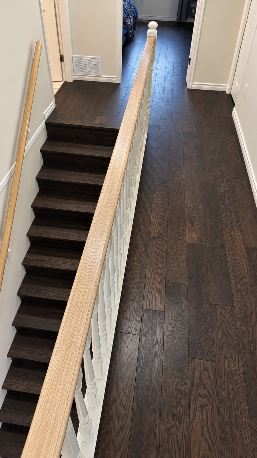 Dark wood staircase with a light handrail