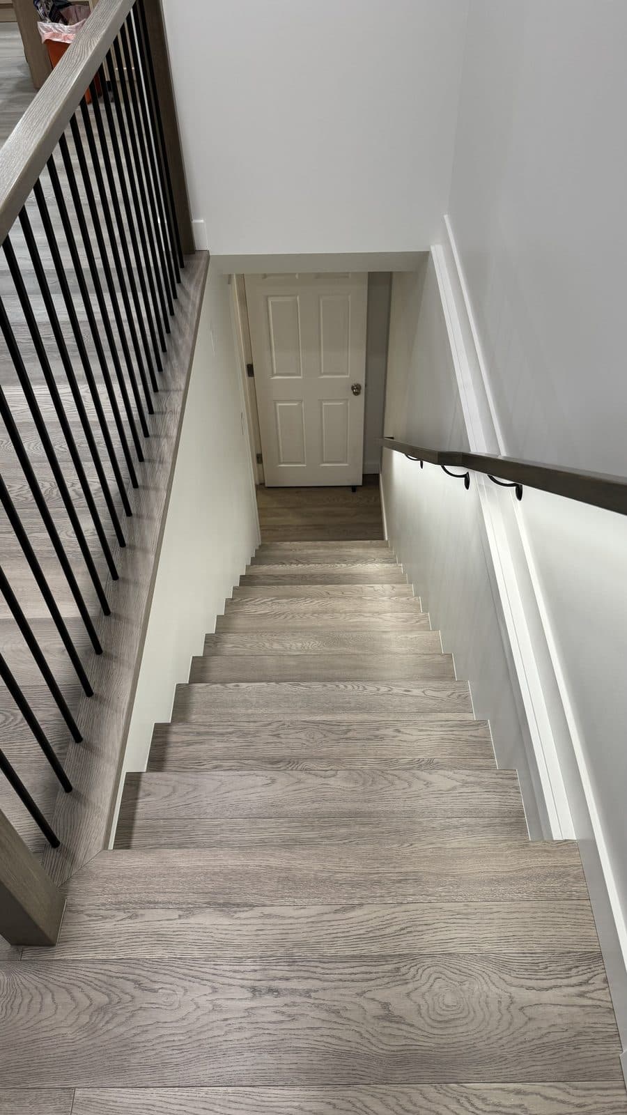 Grey wood staircase with black balusters