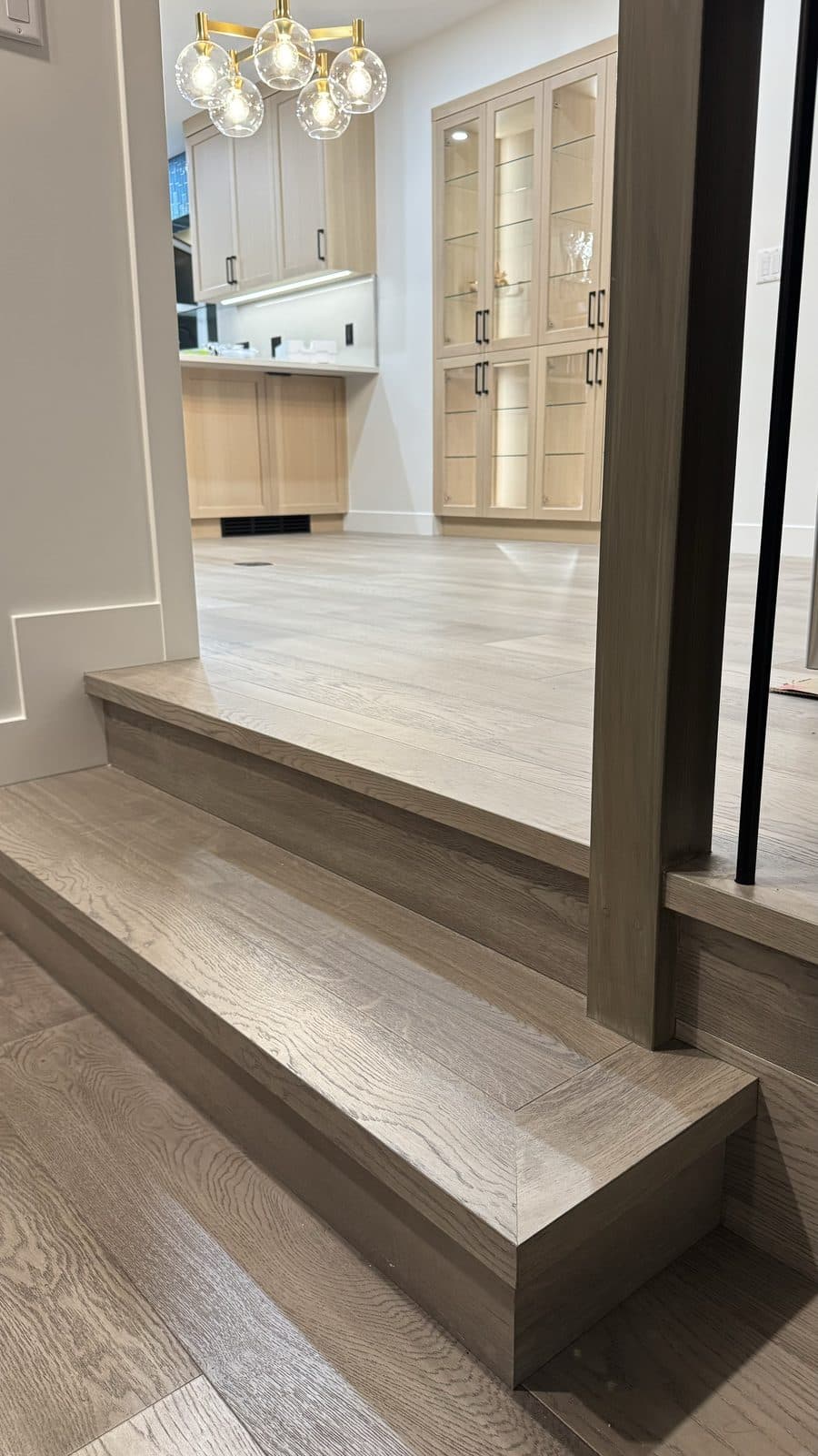 Grey wood step with a square nosing beside a post