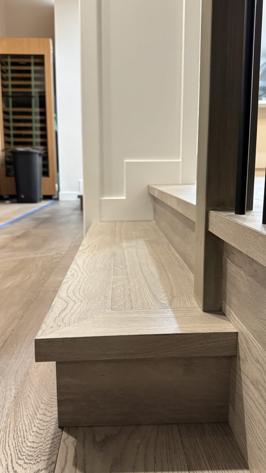Grey wood step with a square nosing along a wall