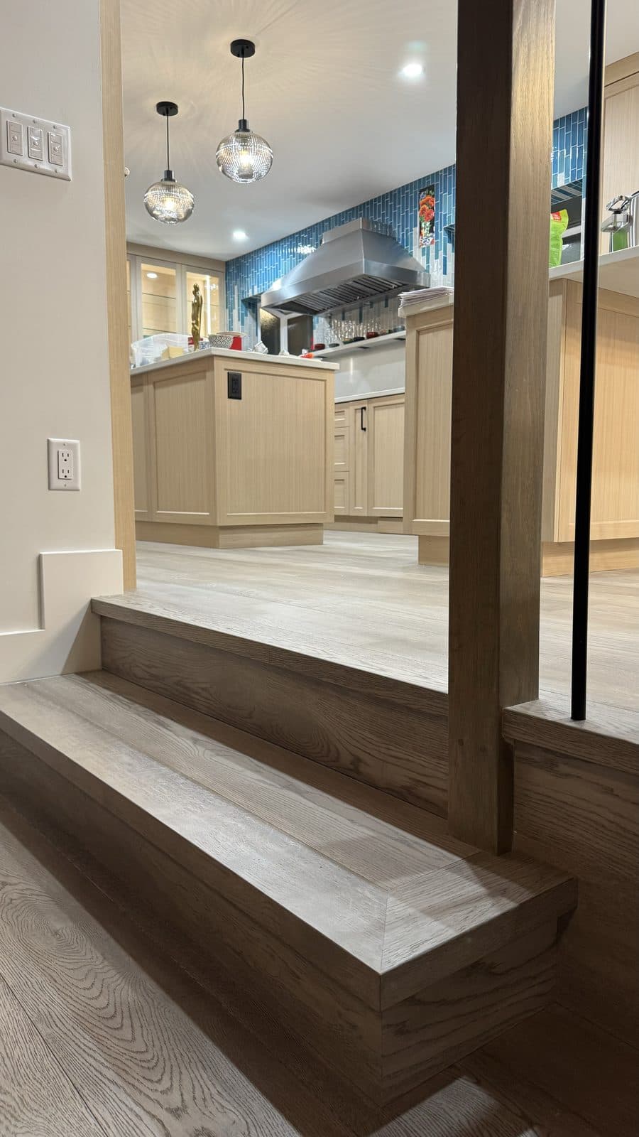 Grey wood steps with square nosings beside a post